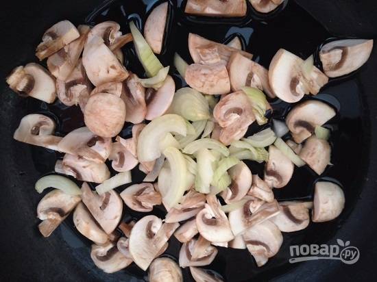 На очень горячей сковороде с растительным маслом обжариваем грибы и нарезанный репчатый лук. 