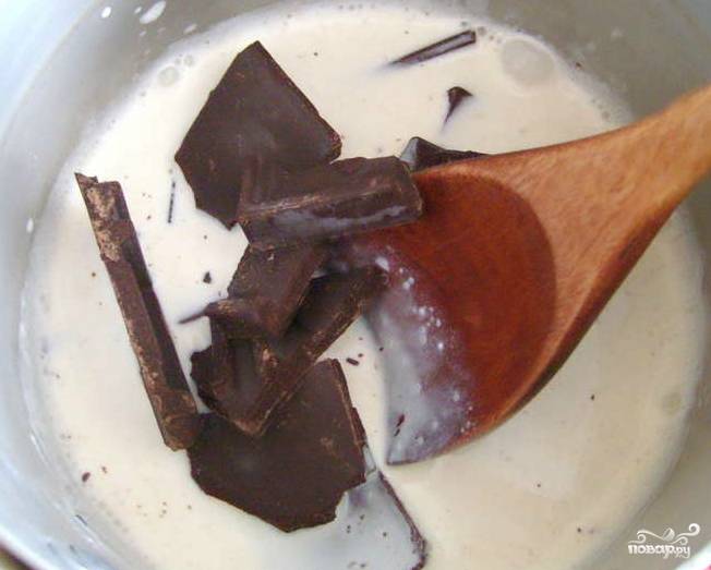 В отдельной кастрюльке кипятим сливки с плиткой горького шоколада, разломанного на кусочки. Должна получиться вязкая шоколадная подлива, которой мы будем заливать наш торт.