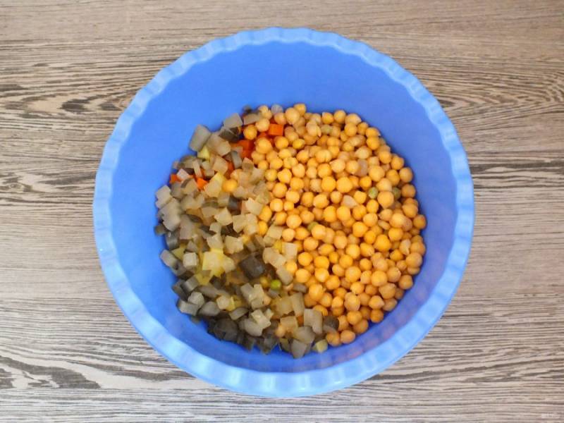 Добавьте нарезанные кубиком маринованные огурцы и отварной нут.