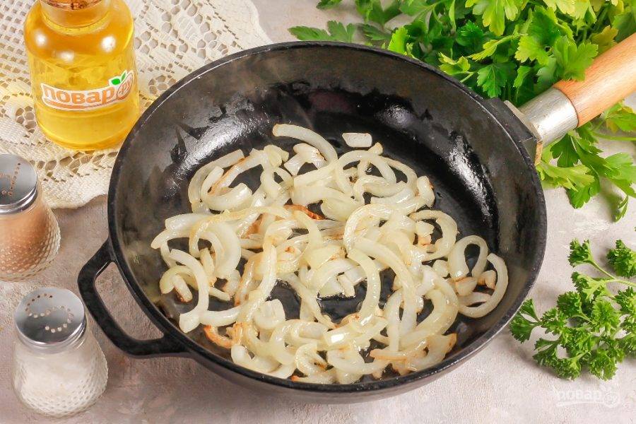 Нарежьте луковицу полукольцами и отпассеруйте в растительном масле на сковороде примерно 3-4 минуты до румяности.