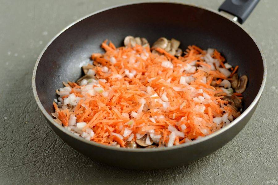 Добавьте в сковороду тертую морковь и лук кубиками. Обжарьте их до мягкости. 