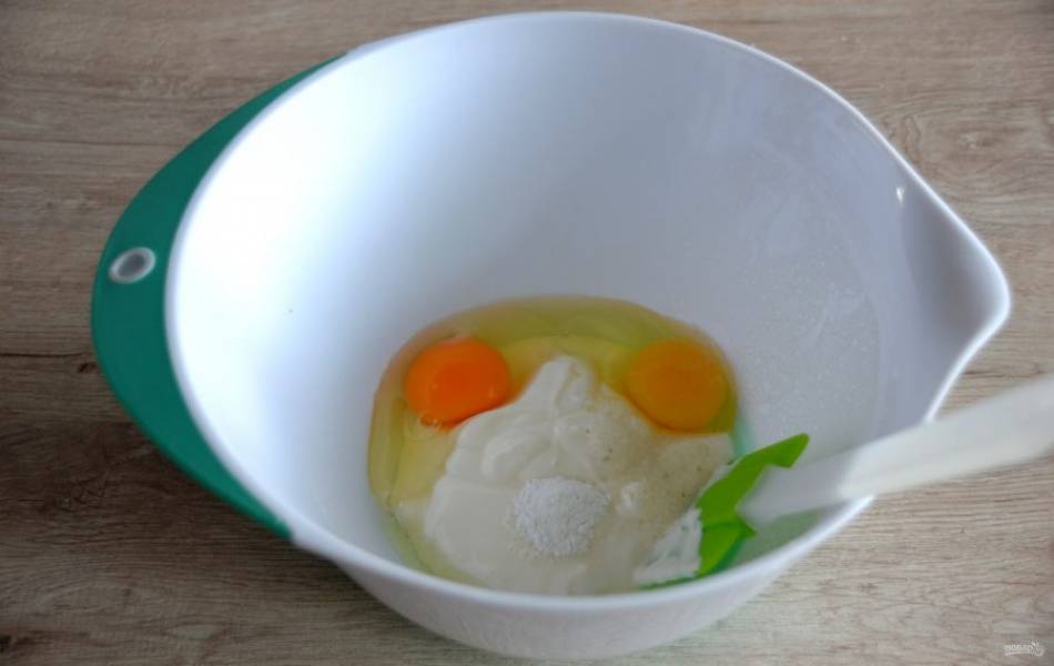 В миске для замешивания теста смешайте яйца со сметаной.