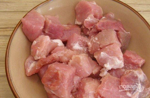 Кусок нежирной свинины (подойдет вырезка, лопатка или задняя часть) вымойте, обсушите и зачистите от лишнего жира. Нарежьте мясо на куски среднего размера. 