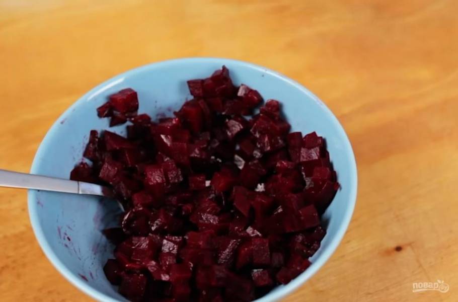 2. После этого нарежьте кубиками свеклу и выложите ее в отдельную миску, заправьте растительным маслом (чтобы она не пустила сок в салате).