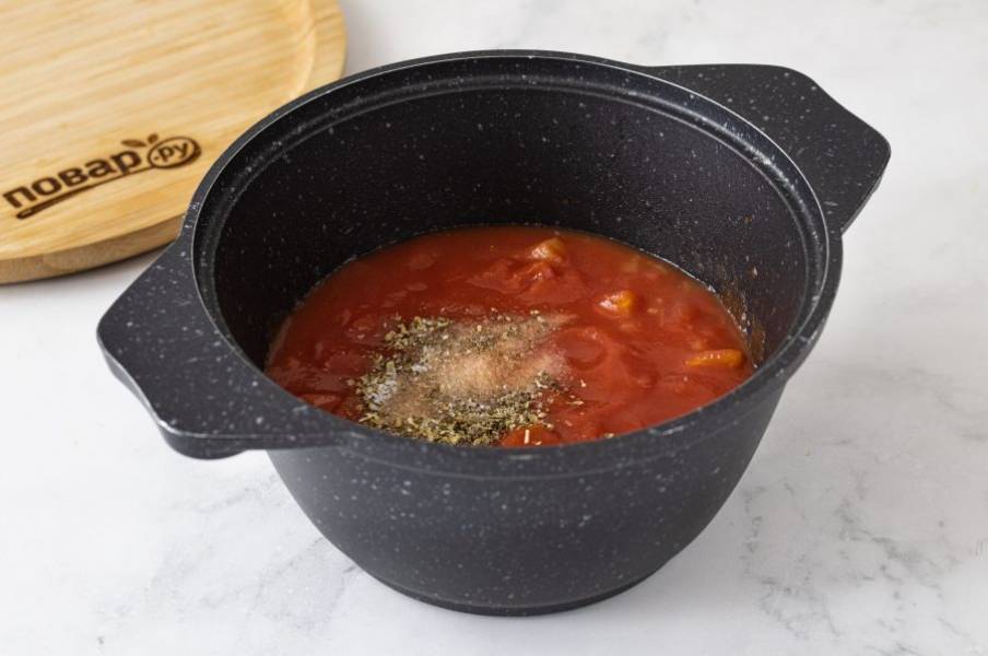 Добавьте измельченные томаты. Посолите, поперчите, приправьте сахаром и сушеными итальянскими травами. На небольшом огне томите соус около 30-35 минут. Он должен загустеть.