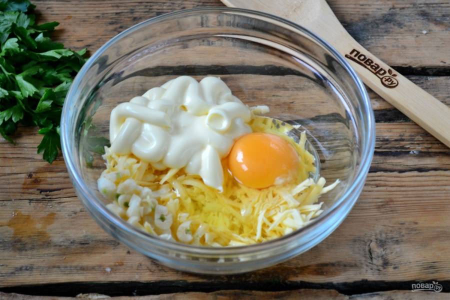 Остальной сыр смешайте с майонезом, измельченным чесноком и одним или двумя яйцами. Хорошо перемешайте полученную смесь.
