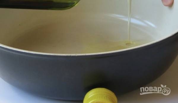 На разогретую сковородку добавьте оливковое масло, выложите лук и чеснок. Готовьте до образования золотой корочки у лука.