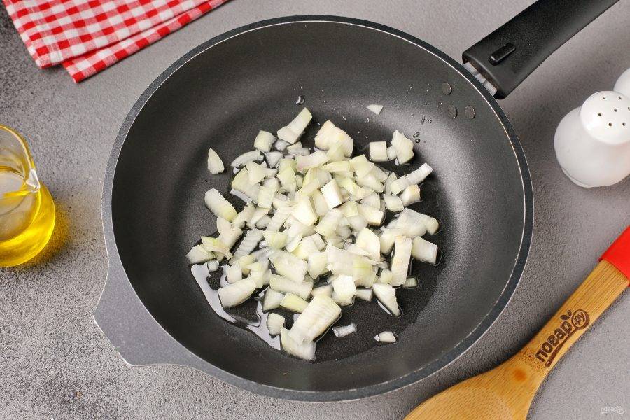 Разогрейте сковороду с маслом и выложите нарезанный кубиками лук.