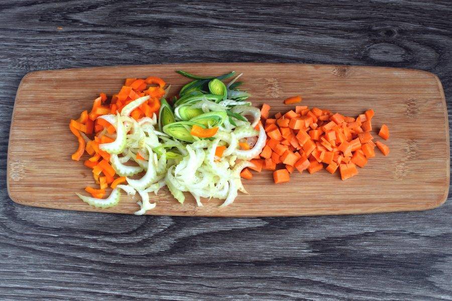 Сельдерей и лук порей тонко нашинкуйте. Сладкий перец нарежьте помельче. Морковь нарежьте кубиками мельче картофеля. Опустите в суп после всплывания фрикаделек. Варите 3 минуты.