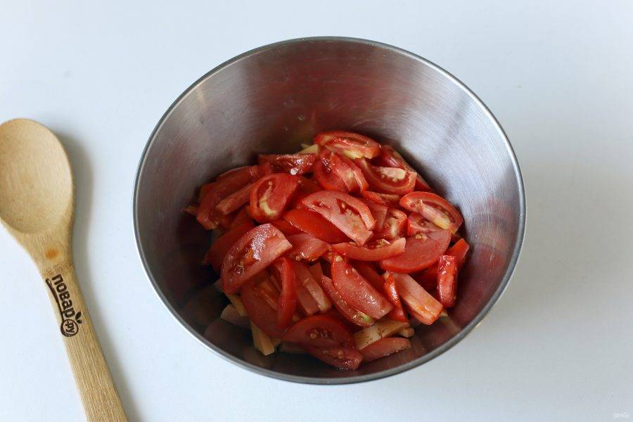 Добавьте нарезанные дольками помидоры.