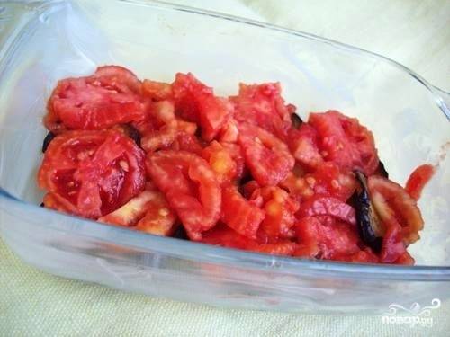 Берем форму для выпекания, смазываем маслом. Выкладываем слой обжаренных баклажанов, сверху укладываем средними кусочками нарезанные помидоры.