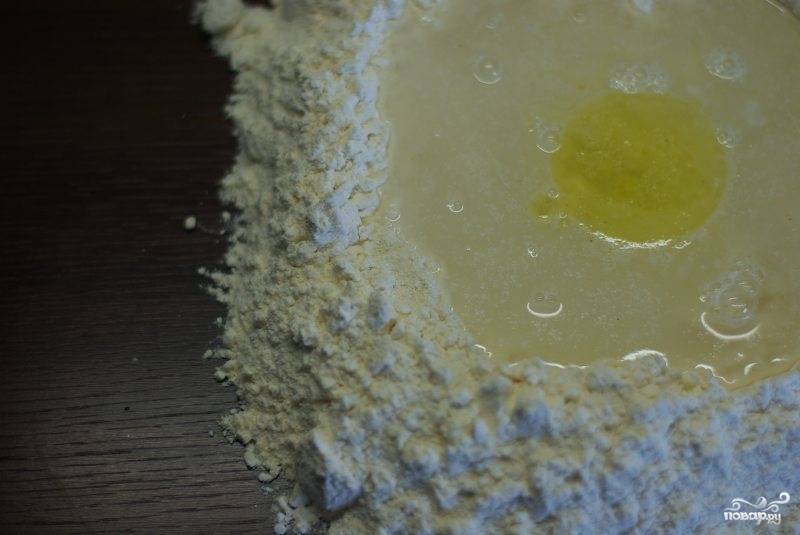 Муку смешиваем с манкой, высыпаем на стол и формируем что-то вроде глубокой посудки. В центр наливаем воду, оливковое масло и добавляем сухие дрожжи. Замешиваем тесто.