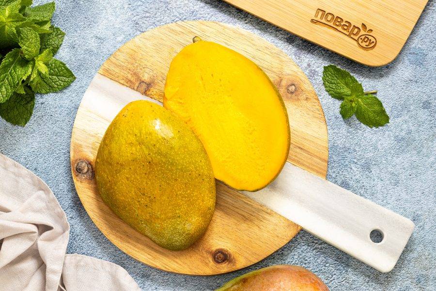 Манго помойте, разрежьте на несколько частей, обходя косточку.