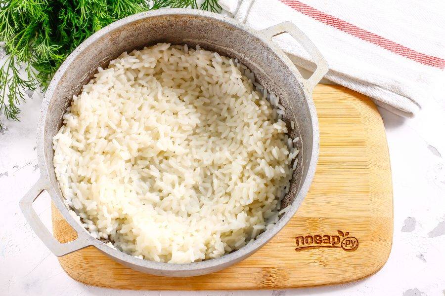 Рис промойте в воде, высыпьте крупу в казан или в ковш. Залейте кипятком и отварите примерно 15 минут на умеренном нагреве, предварительно посолив воду.
