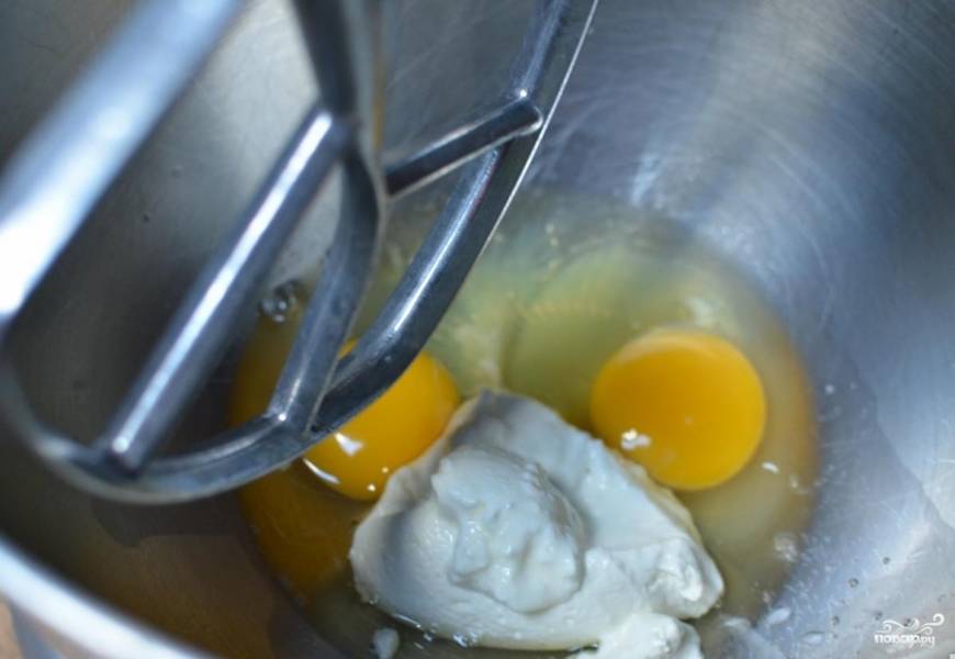 Затем готовим тесто. Для этого в удобной посуде взбиваем миксером яйца с сметаной.