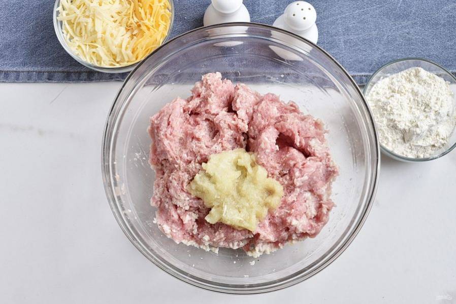 Добавьте в фарш тертый лук, посолите и поперчите по вкусу. Добавьте к фаршу слегка отжатый ломтик батона.