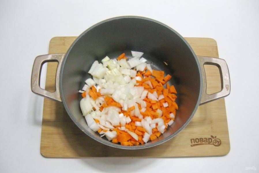 Лук и морковь очистите, помойте и выложите в казан или кастрюлю с толстым дном.