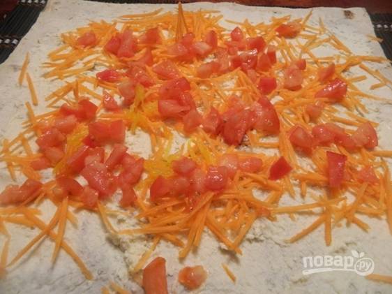 Сверху посыпаем морковкой и выкладываем кусочки помидора. 