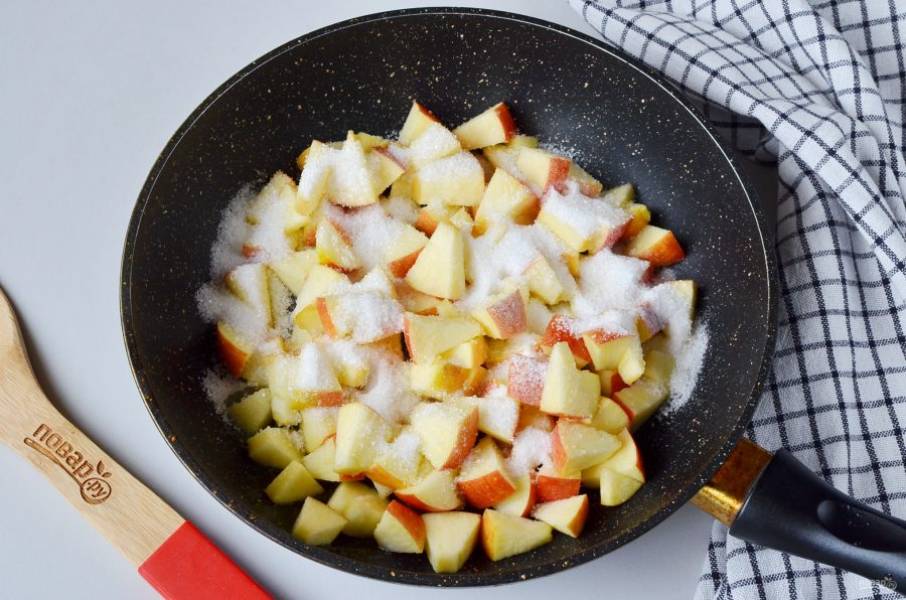 Для начинки вымойте яблоки, удалите сердцевинки, порежьте кусочками. Растопите сливочное масло и обжарьте несколько минут яблоки с сахаром.
