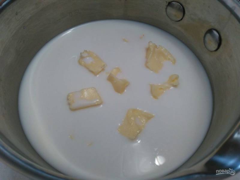Сливочное масло порежьте кубиками и поместите в ковш, туда же влейте молоко. Нагревайте смесь на среднем огне до растапливания масла.