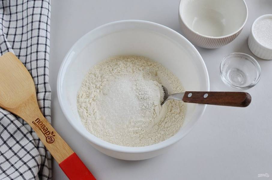 Включите духовку на 180 градусов. В миску просейте муку, добавьте разрыхлитель, щепотку соли и сахар. Перемешайте хорошо.