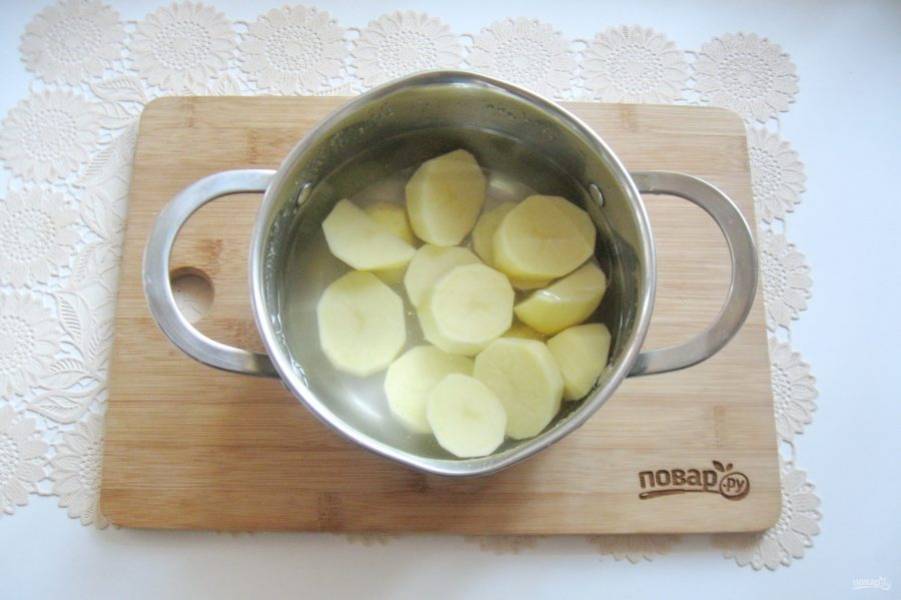 Картофель очистите, выложите в кастрюлю и залейте водой. Посолите по вкусу. Поставьте на плиту.