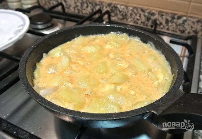 4.	Вылейте лишнее масло со сковороды, оставьте 1 столовую ложку, вылейте яичную смесь с овощами, накройте крышкой и обжаривайте несколько минут.