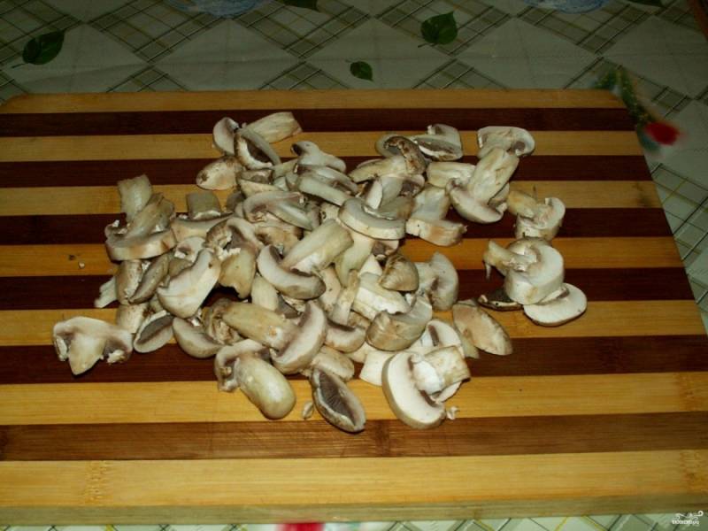 5. Хорошо вымойте и очистите шампиньоны. Потом нарежьте грибы плоскими кусочками. 