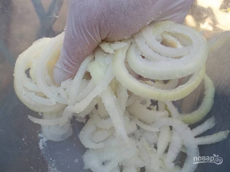 Нарежьте очищенный и промытый репчатый лук. Перетирая руками, смешайте лук с солью.