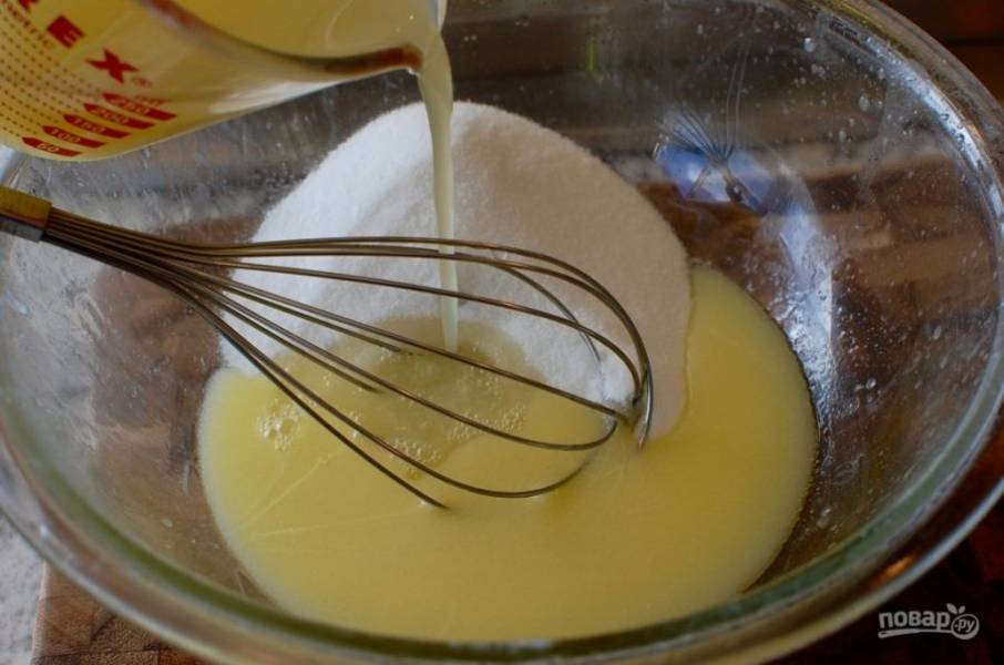 2.	Добавьте в миску с растопленным маслом цедру лимона, сахар и лимонный сок, тщательно перемешайте с помощью венчика.