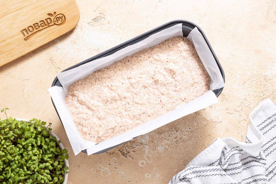 Выложите тесто в форму для выпечки застеленную пергаментом. Выпекайте хлеб в разогретой до 180 градусов духовке около 50 минут.