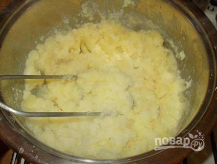Сливаем воду с готового картофеля, добавляем сливочное масло и толкушкой разминаем картофель в пюре.