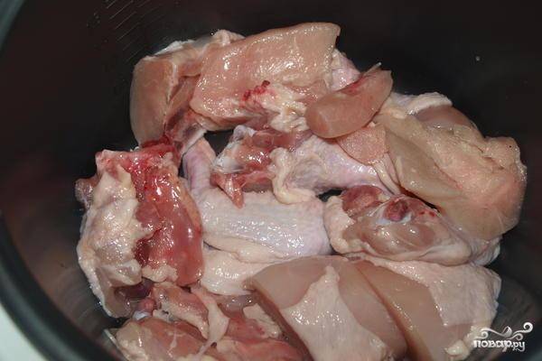 Курицу хорошенько промываем, разделяем на порционные куски. В чашу мультиварки нальем масла и сложим туда кусочки курочки.