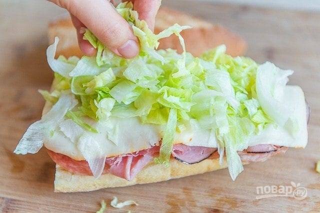 3. Затем - два кусочка сыра, а сверху разложите нашинкованный латук.
