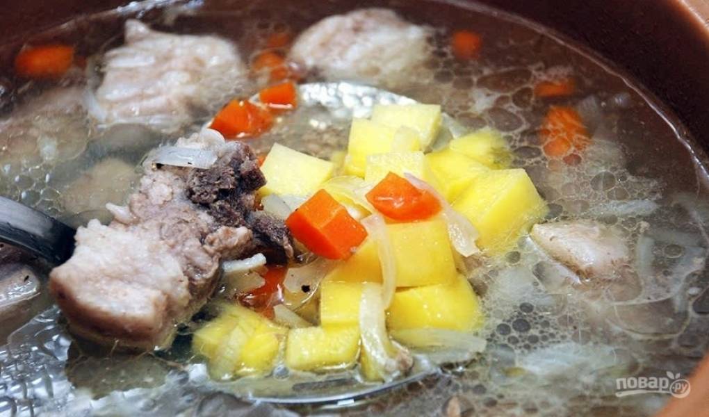Картофель вымойте и очистите от кожуры острым ножом. Затем нарежьте его на кубики среднего размера. Положите картофель в кастрюльку к остальным ингредиентам.