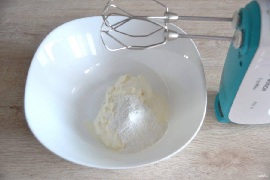 Для приготовления крема взбейте охлажденные сливки с 1 ст. ложкой сахарной пудры и ванильным сахаром. Взбивайте до плотной массы.
