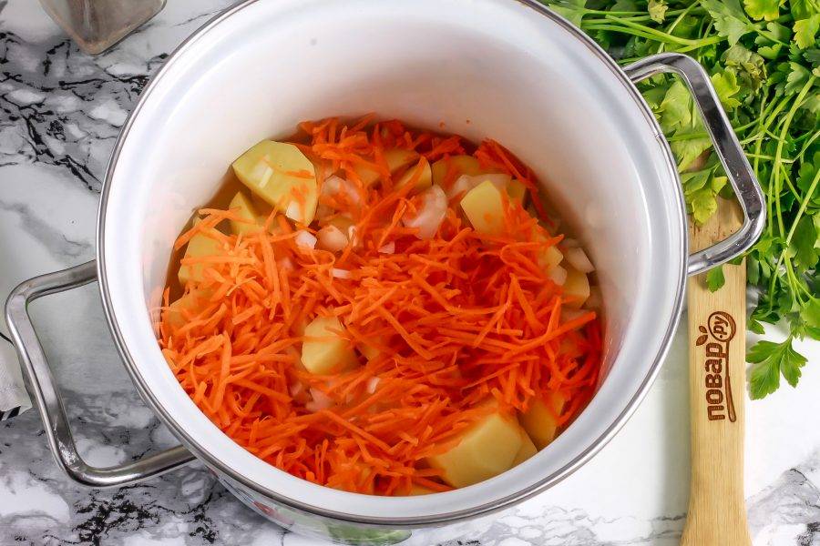 Морковь натрите на терке с мелкими ячейками и добавьте в емкость. Влейте теплую воду в кастрюлю и поместите ее на плиту. Отварите примерно 10 минут с момента закипания воды в емкости.