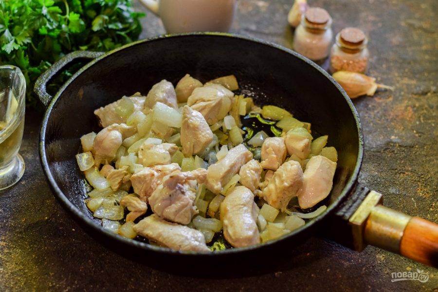 В сковороде прогрейте растительное масло, выложите курицу и лук — жарьте 5-6 минут на небольшом огне.