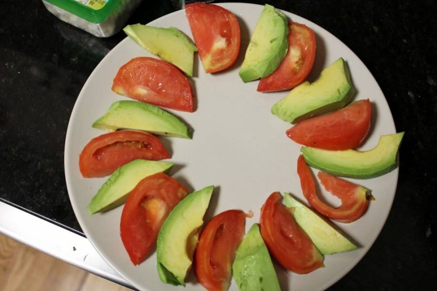 3. В большую сервировочную тарелку по кругу выкладываем дольки авокадо и помидора, чередуя их.