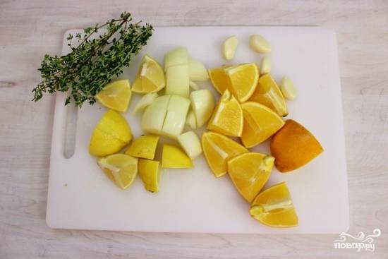 Разрежьте апельсин, лимон, лук и чеснок на дольки.
