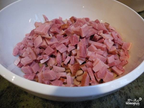 2. Ветчину нарежьте мелкими кубиками. Кстати, использовать в рецепт приготовления салата с бобами и ветчиной можно также немного копченостей для более насыщенного вкуса. 