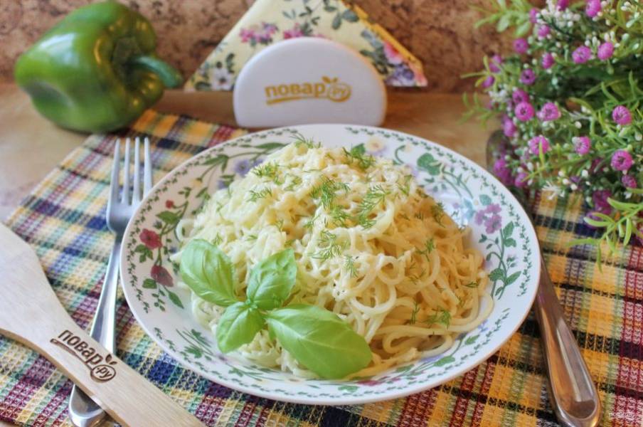 Спагетти с сыром и чесноком украсьте зеленью и подавайте в горячем виде.