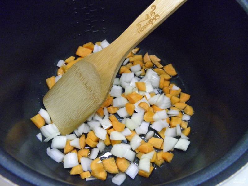 Порежьте лук и морковь средними кусочками. Обжарьте их в мультиварке на растительном масле в режиме "Подогрев" или "Обычный". 