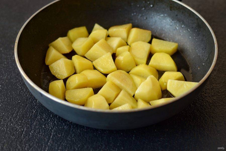 Очистите картошку, нарежьте на крупные ломтики. Обжарьте на сильном  огне почти до готовности. Переложите в миску. 