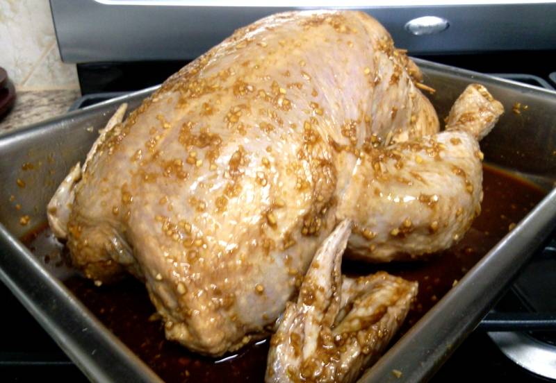 Итак, промываем и вытираем насухо тушку курицы. Затем измельчаем кусочек свежего имбиря и 5-6 зубчиков чеснока, выкладываем их в мисочку, добавляем 4,5 ложки устричного соуса, 3 ложки соевого, белый молотый перец и соль по вкусу, перемешиваем ингредиенты - соус готов. Натираем соусом курицу (внутри и снаружи, а также под кожей) и оставляем ее на ночь мариноваться в холодильнике. Рис следует также замочить на ночь в теплой воде, она должна на 2-2,5 см подниматься над крупой.