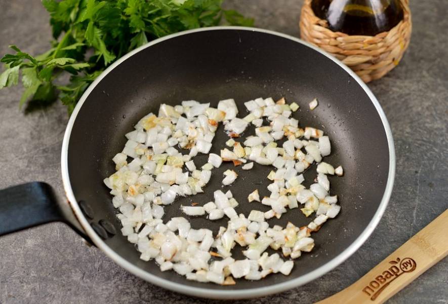 Пока гречка варится, разогрейте в сковороде растительное масло, обжарьте на нем нарезанный мелким кубиком репчатый лук до мягкости.
