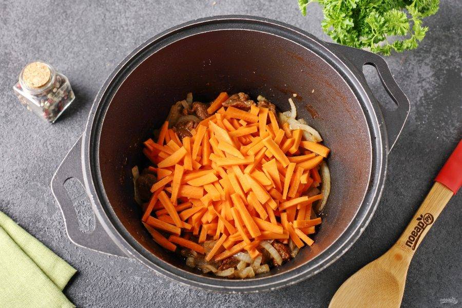Добавьте нарезанную соломкой морковь и продолжайте готовить еще 7-10 минут.