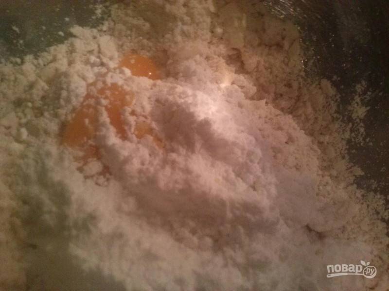 В полученную крошку добавьте яичный желток, сахарную пудру и щепотку соли.
