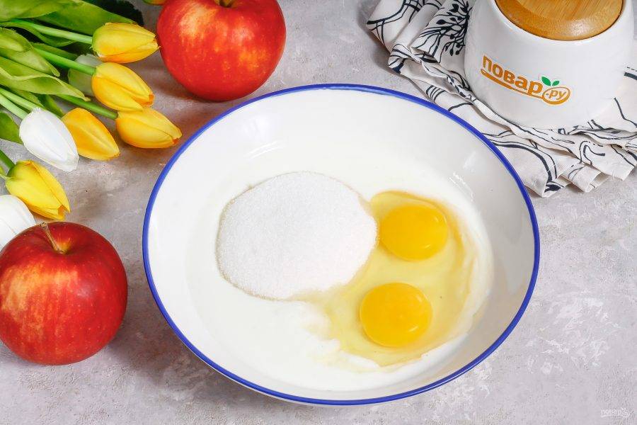 Вбейте куриные яйца в глубокую емкость, влейте кефир любой жирности, всыпьте соль и сахарный песок. Тщательно взбейте.