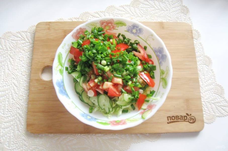 Зеленый лук помойте и мелко нарежьте. Выложите в салат.